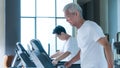 Healthy Asian senior couple exercise together in gym running treadmill Royalty Free Stock Photo