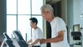 Healthy Asian senior couple exercise together in gym running treadmill Royalty Free Stock Photo