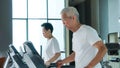 Healthy Asian senior couple exercise together in gym running treadmill Royalty Free Stock Photo