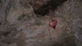 Old heart shaped fabric decoration hanging on stone ceiling, heartbreak, breakup