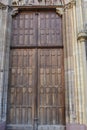 Old heavy square, wooden, massive, shafted door in stone wall to enter St. Martin`s Church in Gothic architectural style Royalty Free Stock Photo