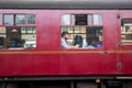 Old heritage train railway cariage passengers seated and looking out of the window. Viewed from outside