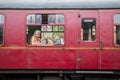 Old heritage train railway cariage with smiling woman seated inside looking out of the window Royalty Free Stock Photo