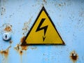 Old high voltage sign on a blue rusty door Royalty Free Stock Photo