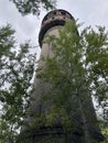 Old high water tower surrounded by trees. Brick tower in countryside. Royalty Free Stock Photo