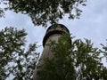 Old high water tower surrounded by trees. Brick tower in countryside. Royalty Free Stock Photo