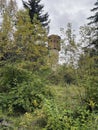 Old high water tower surrounded by trees. Brick tower in countryside. Royalty Free Stock Photo