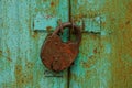 Large rusty brown padlock on the iron green gates Royalty Free Stock Photo