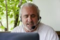 old hispanic man in headphones. Knowledgeable digital tutor providing online learning support. Tech-savvy tutor leveraging digital