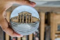 Old historic building of Art Gallery of New South Wales photography in clear crystal glass ball with left male hand holding.