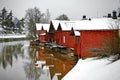 Old historic Porvoo, Finland. Red coloured vintage wooden barns storage houses on the riverside with snow in winter Royalty Free Stock Photo