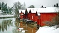 Old historic Porvoo, Finland. Red coloured vintage wooden barns storage houses on the riverside with snow in winter Royalty Free Stock Photo