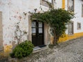 Old historic rustic mediterranean white wall house building wooden door entrance exterior facade in Obidos Portugal Royalty Free Stock Photo