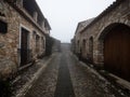 Old historic traditional stone buildings exterior house facade in dense fog mood Pia do Urso Batalha Portugal Europe Royalty Free Stock Photo