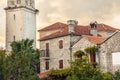 Old historical building facade with orange roof tiles in retro vintage style during sunset in old European town