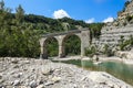 Old historical stone bridge on river in the mountains Royalty Free Stock Photo
