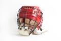 An old hockey helmet of red color with a protective iron mask on a white background Royalty Free Stock Photo