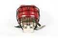 An old hockey helmet of red color with a protective iron mask on a white background Royalty Free Stock Photo