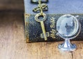 The old holy bible with metal key and globe icon on wooden background Royalty Free Stock Photo