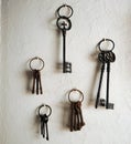 Antiques iron keys hanging on a house whitewashed wall