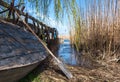 An old homemade boat in front of the river entrance, overgrown with reeds Royalty Free Stock Photo