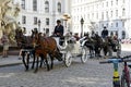 Old horse-drawn carriage riding on city street at Hofburg palace in Vienna. Horse carriages  in vintage style carriages with Royalty Free Stock Photo