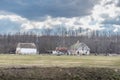 Old horse farm with rural houses and horses grazing in the field Royalty Free Stock Photo