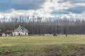 Old horse farm with rural houses and horses grazing in the field Royalty Free Stock Photo