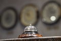 Old hotel bell on a marble stand with clocks in background Royalty Free Stock Photo