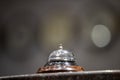 Old hotel bell on a marble stand with clocks in background Royalty Free Stock Photo