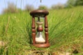 Old hourglass in grass