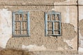 old house adobe air brick wall with two embedded wooden window frames and peeled off plaster leftovers - flat texture Royalty Free Stock Photo