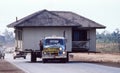 Old house being relocated on the back of a low loader truck