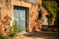 Old house with big light blue gate in one of the most beautiful villages of France Roussillion, Provence. Stone walls painted in