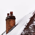 Old house clay brick chimney in winter covered with snow