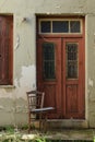 Old house door and wooden chair on grassed porch Royalty Free Stock Photo