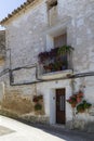 Old house facade, with pots of geraniums hanging on the wall and on its balcony in Fuendetodos, the birthplace of the Spanish Royalty Free Stock Photo