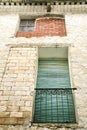 Old house facade with rusty balcony and green blind Royalty Free Stock Photo