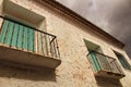 Old house facade with rusty balcony and green blind Royalty Free Stock Photo