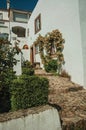 Old house and flowered window in cobblestone alley with steps Royalty Free Stock Photo