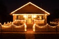 An old house with front porch and picket fence decorated with Christmas lights Royalty Free Stock Photo