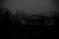 Old house with a Ghost in the forest at night or Abandoned Haunted Horror House in fog. Old mystic building in dead tree forest. C Royalty Free Stock Photo