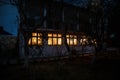 Old house with a Ghost in the forest at night or Abandoned Haunted Horror House in fog. Old mystic building in dead tree forest. Royalty Free Stock Photo