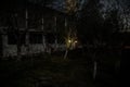 Old house with a Ghost in the forest at night or Abandoned Haunted Horror House in fog. Old mystic building in dead tree forest. Royalty Free Stock Photo