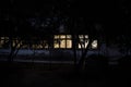 Old house with a Ghost in the forest at night or Abandoned Haunted Horror House. Old mystic building in dead tree forest. Surreal