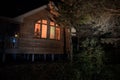 Old house with a Ghost in the forest at night or Abandoned Haunted Horror House in fog. Old mystic building in dead tree forest. Royalty Free Stock Photo