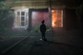 Old house with a Ghost in the forest at night. Horror silhouette at the window. Old building in forest. Surreal lights. Horror