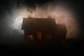 Old house with a Ghost in the moonlit night or Abandoned Haunted Horror House in fog, Old mystic villa with surreal big full moon.