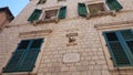 Old house with green ancient closed and open windows and shutters Royalty Free Stock Photo