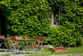 Old house  with green overgrown ivy and cafe tables Royalty Free Stock Photo